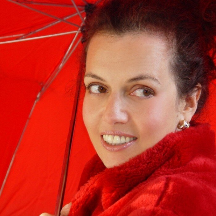 žena u crvenom kaputu i s crvenim kišobranom