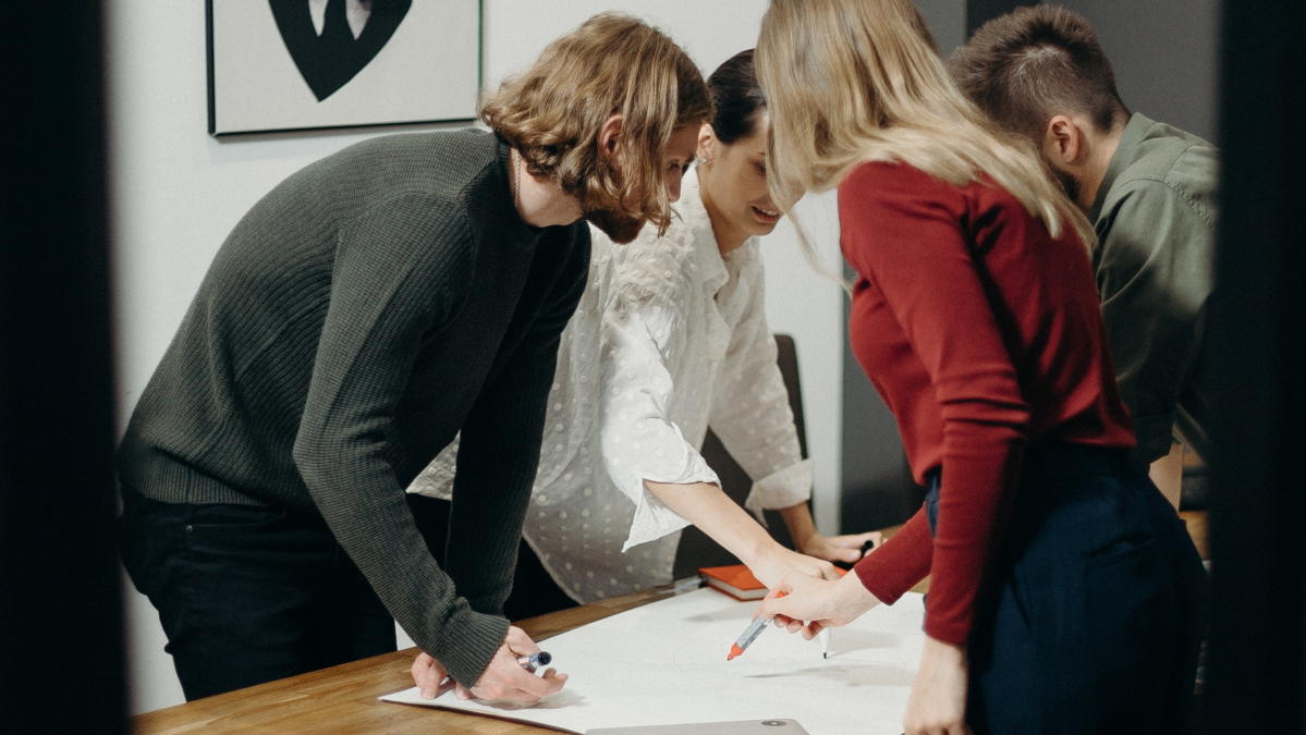 Grupa ljudi oko stola proučava plan za krizno komuniciranje