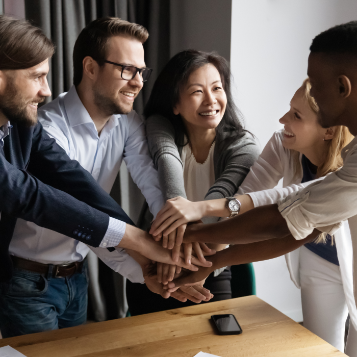 Mladi ljudi iznad stola su spojili dlanove