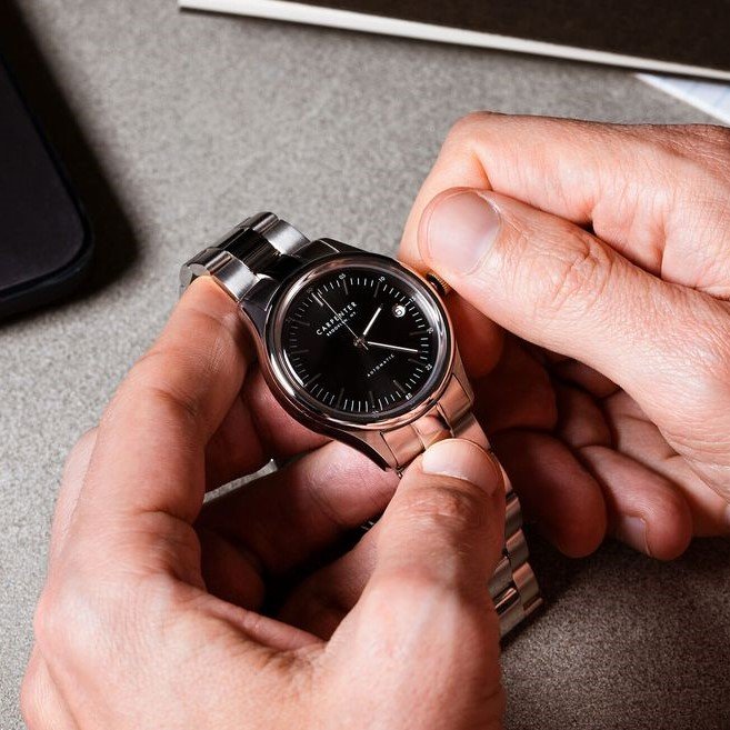 Muškarac namiješta vrijeme na ručnom satu