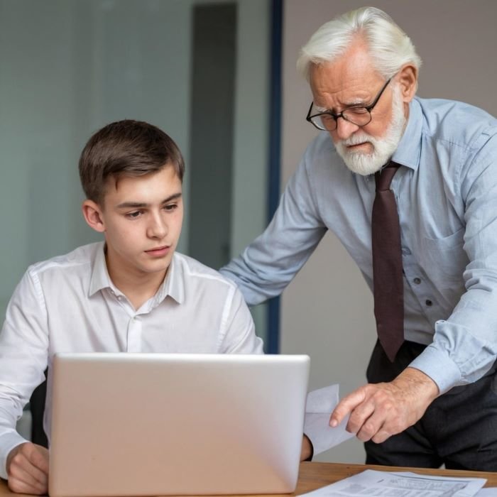 Stariji muškarac pokazuje i prenosi znanje na mlađeg kolegu 